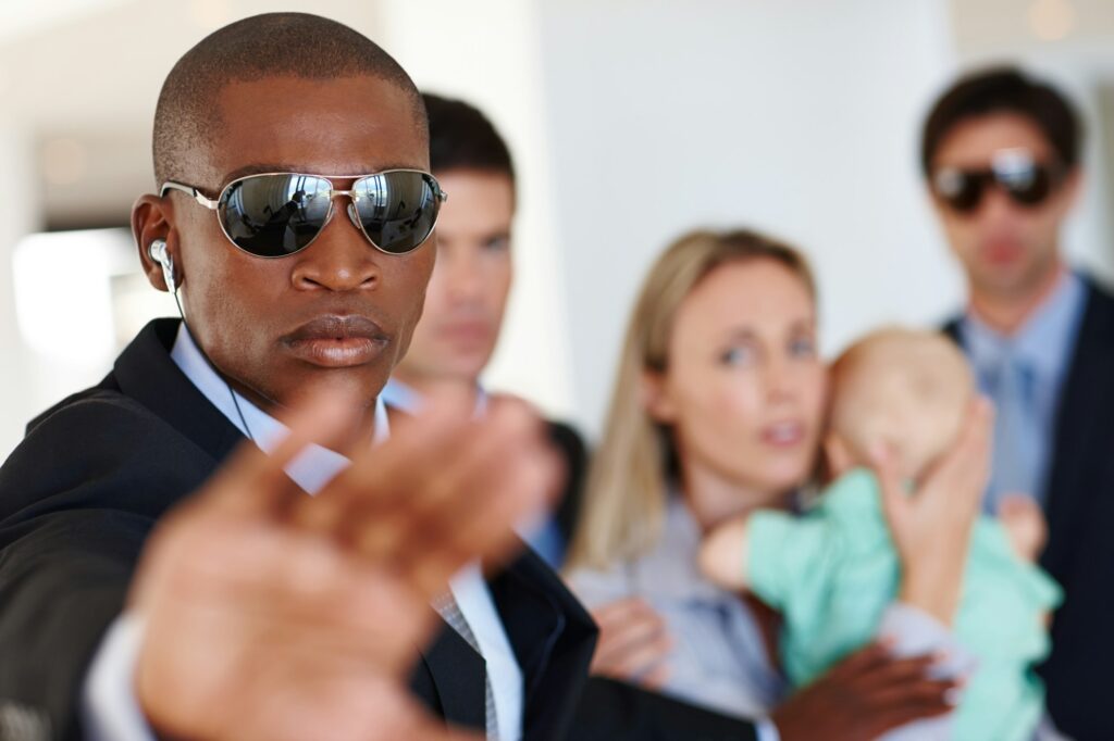 Its his job to protect and serve. Shot of a bodyguard shielding his clients at a public event.